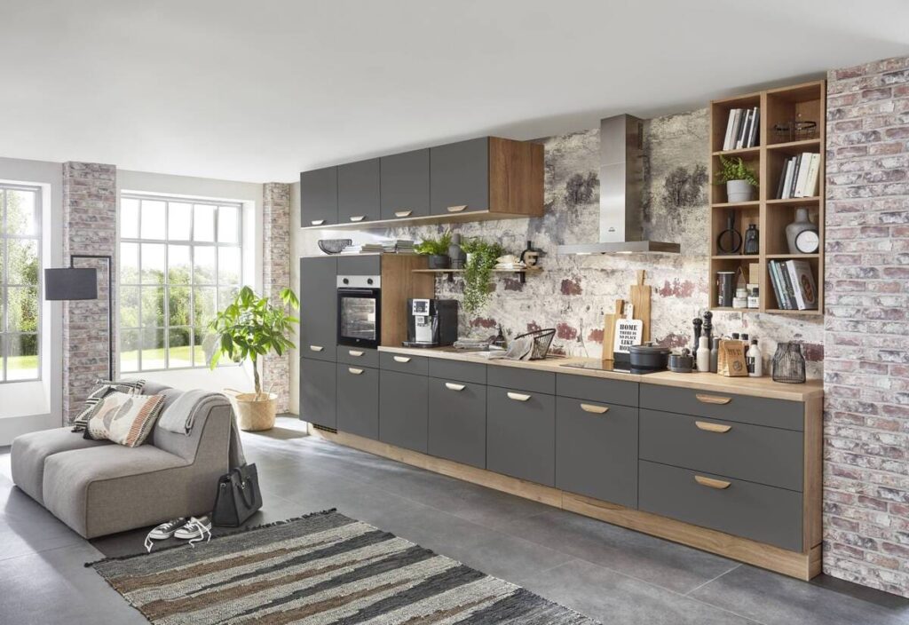 A contemporary kitchen design with gray cabinets contrasted by an exposed brick wall.