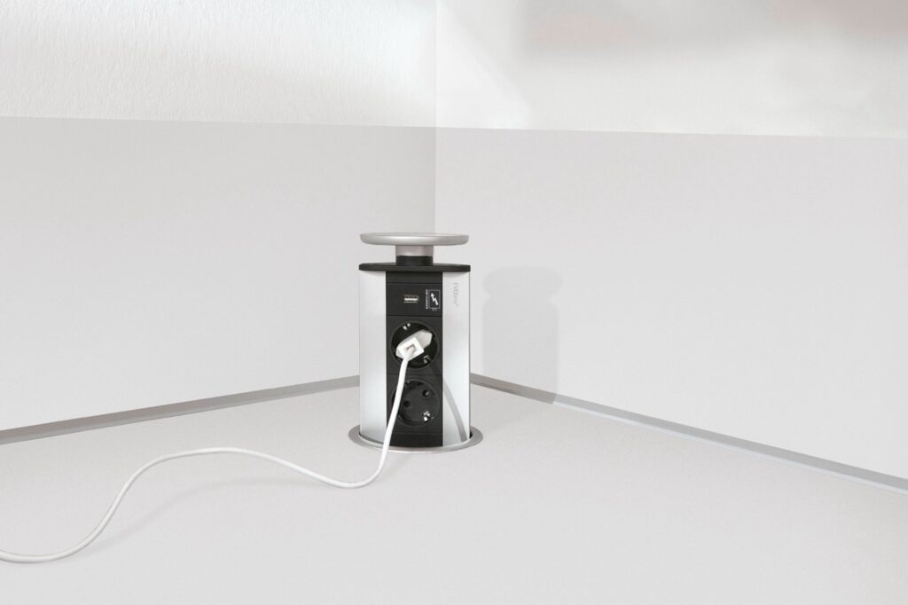 A modern kitchen interior design detail: a pop-up power outlet integrated into the countertop for a sleek and functional workspace.