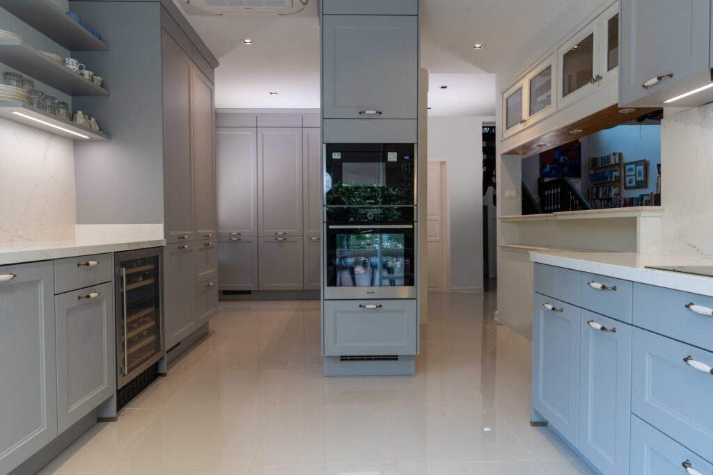 Stone grey kitchen cabinets featuring an integrated wine fridge, blending modern function with cottage kitchen style.