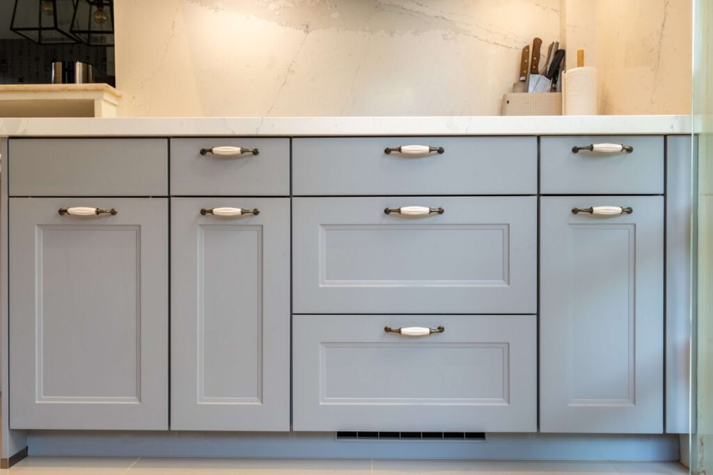 Close-up of stone grey CASCADA framed drawers with classic hardware, showcasing a modern cottage kitchen aesthetic.