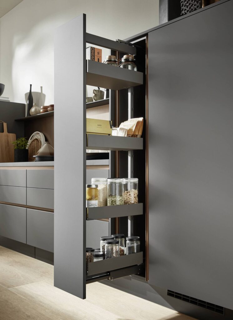 A tall, grey slimline pantry pull-out cabinet revealing organized vertical storage for dry goods, utilizing a small floor footprint essential for minimal kitchens in condos